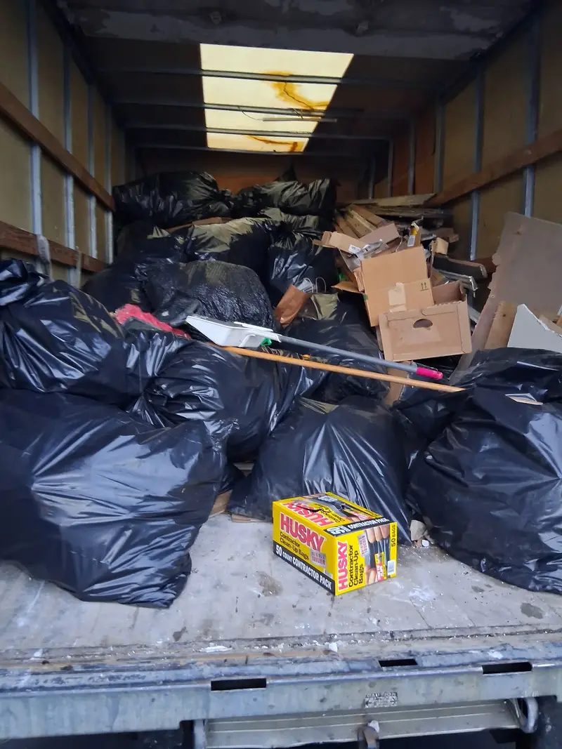 Before photo of a cluttered garage filled with old toys, tools, and junk needing professional cleanup